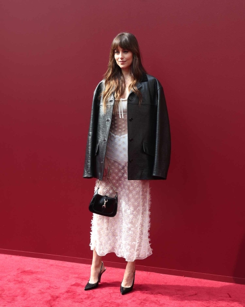 Dakota Johnson wore a sheer white boho midi dress paired with a cracked black leather jacket to the Gucci Women's Spring Summer 2025 Fashion Show during the Milan Fashion Week.