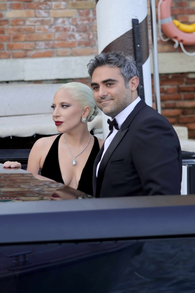 Lady Gaga appeared at Venice Film Festival wearing a giant black ballgown with a petal-like hoop skirt and a plunging neckline along with a towering black lace headpiece. The event marked her red carpet debut with fiancé Michael Polansky.