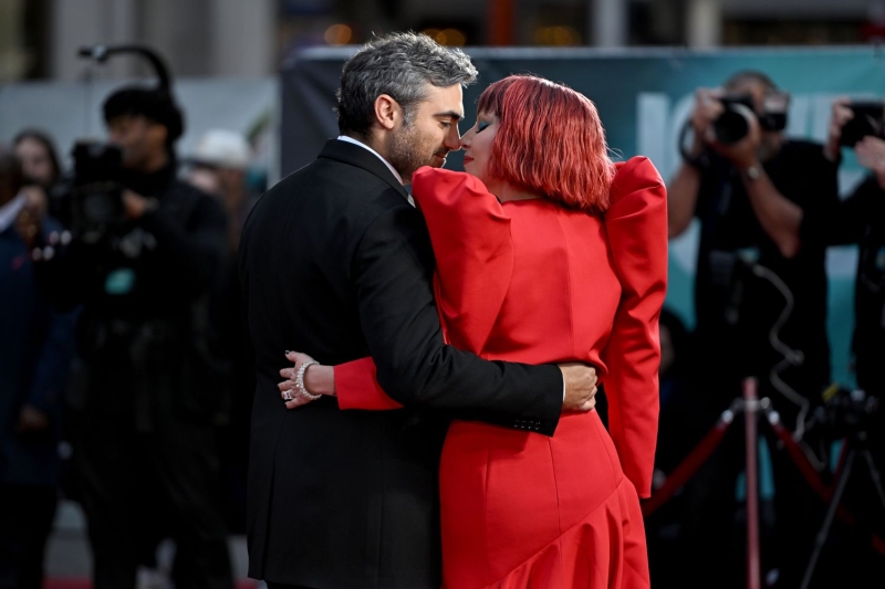 Lady Gaga paid homage to her song 'Bad Romance' in a red gown with structured shoulders and black-and-maroon blunt bob for the U.K. premiere of 'Joker Folie à Deux.'