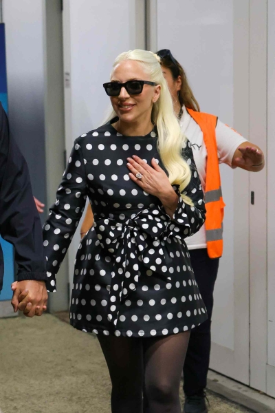 Lady Gaga showed off her huge oval diamond engagement ring and waist-length platinum blonde hair while stepping out in a "very demure" minidress with fiancé Michael Polansky at the Venice Film Festival on September 2.