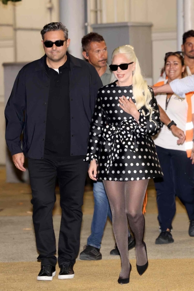 Lady Gaga showed off her huge oval diamond engagement ring and waist-length platinum blonde hair while stepping out in a "very demure" minidress with fiancé Michael Polansky at the Venice Film Festival on September 2.