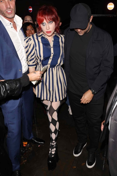 Lady Gaga wore checkered shorts and a striped dress with a shaggy red wig for a fan event in London. See her full "Harlequin" and Harley Quinn-inspired look, here.