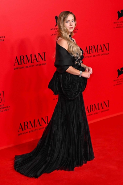 Sydney Sweeney attended an Armani dinner in Venice while wearing a sheer optical illusion dress with floral detailing. See her full look, here.