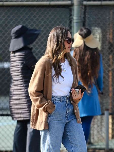 Jessica Alba wore an effortlessly chic slouchy camel cardigan with baggy jeans before changing into a divisive Y2K fashion combo for the "Diane von Furstenberg: Woman Before Fashion" exhibit in Los Angeles on Tuesday, October 15.