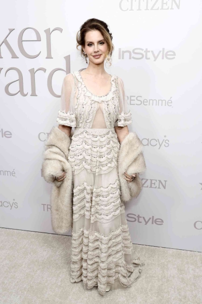 Lana Del Rey attended InStyle's Imagemaker Awards in an ethereal ivory gown with sheer sleeves and tiered ruffles. See her full look, here.