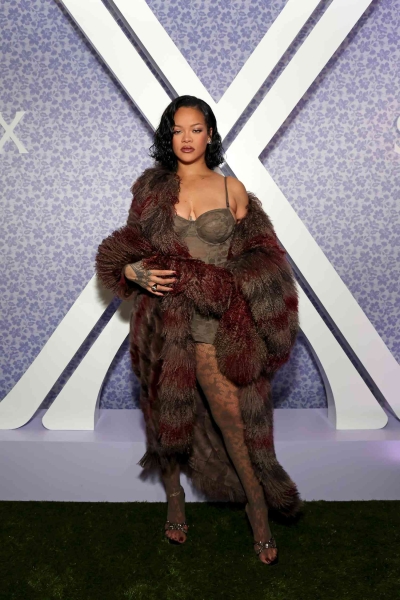 Rihanna looked like she was taking style inspiration from the 2000s wearing a Y2K-inspired corseted camo lace mini dress with matching sheer tights at the Savage X Fenty Lavish Lace collection launch on October 10.