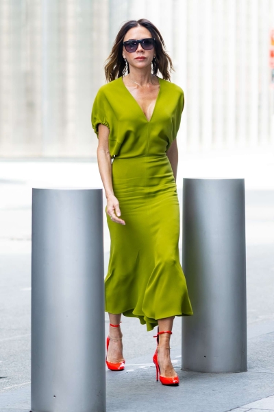 Victoria Beckham stepped out in New York City in a slinky green dress paired with bright red heels for an unexpected fall look.