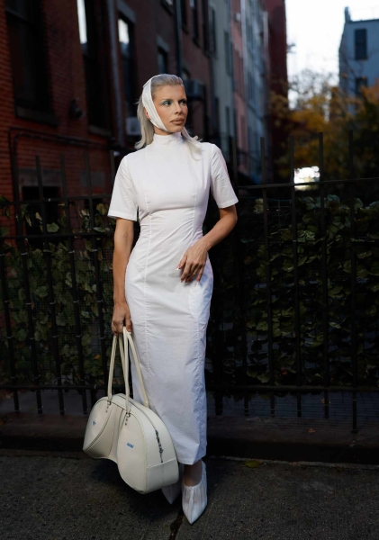 Julia Fox was spotted in New York City in another sartorial creation that broke all of the fashion rules—this time, a white apron dress that was completely backless paired with a white bandage-inspired headband.