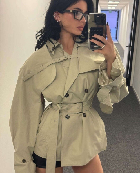 Kylie Jenner leaned into the office siren trend by wearing a pair of Miu Miu glasses with a cropped trench coat and mini skirt while running errands in Los Angeles on Saturday, November 17.