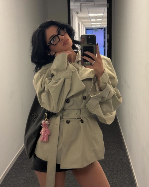 Kylie Jenner leaned into the office siren trend by wearing a pair of Miu Miu glasses with a cropped trench coat and mini skirt while running errands in Los Angeles on Saturday, November 17.