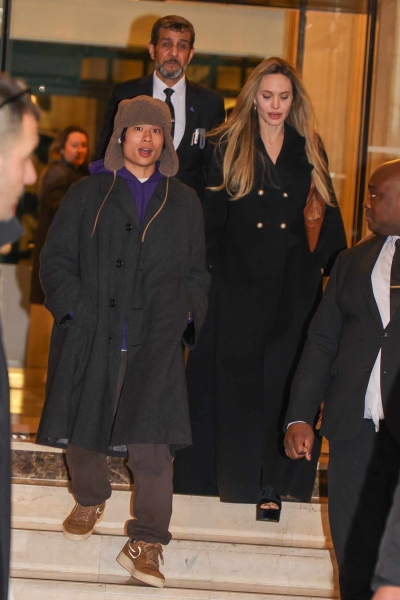 Angelina Jolie stepped out in Paris with her son Pax wearing a black wool winter coat with a pair of platform sandals. See her unconventional cold-weather shoes, here.