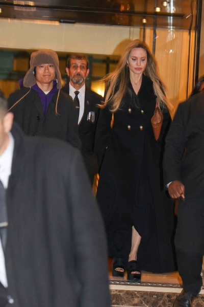 Angelina Jolie stepped out in Paris with her son Pax wearing a black wool winter coat with a pair of platform sandals. See her unconventional cold-weather shoes, here.