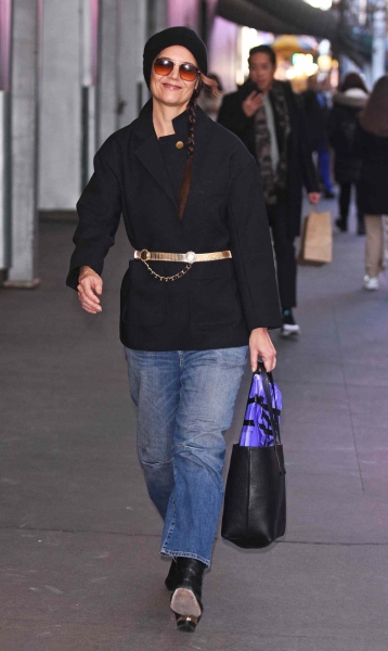 Katie Holmes was spotted on December 18, 2024, wearing a black coat with a bright gold belt along with blue jeans and black leather boots. See the outfit here.