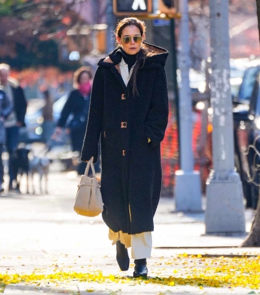 Katie Holmes wore an oversize black coat in New York City on December 1, 2024, and paired it with a white outfit underneath, breaking the rule of no white after Labor Day.