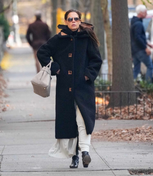 Katie Holmes wore an oversize black coat in New York City on December 1, 2024, and paired it with a white outfit underneath, breaking the rule of no white after Labor Day.